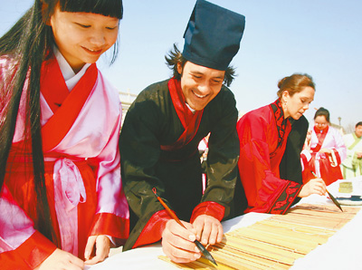 Foreigners learn to wear traditional Chinese Han clothes, practice bamboo calligraphy, and play ancient Chinese musical instruments in the Beijing World Park on March 30, 2011. The activities held before the Qingming Festival attracted tourists from Russia, France, Australia and South Africa here to experience traditional Chinese culture.