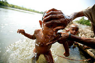 Bathing a young child in the April River, Pukapuki village, Papua New Guinea. [WWF] 