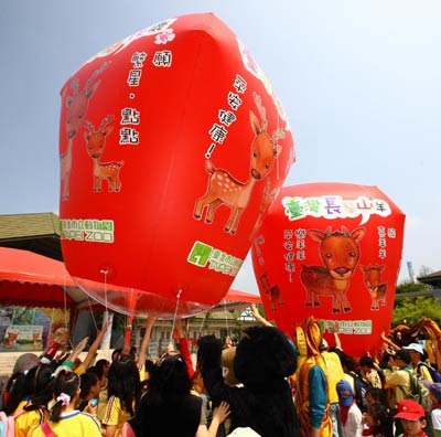 Taiwan children present balloons wishing the animals a healthy and happy life, at Taipei Zoo, Taiwan, on April 7, 2011. 