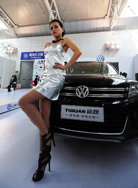 A model promotes a car at an auto show in Yantai of east China's Shandong Province, April 8, 2011. A total of 700 automobiles from 69 brands were displayed in the exhibition.[Xinhua/Chu Yang]