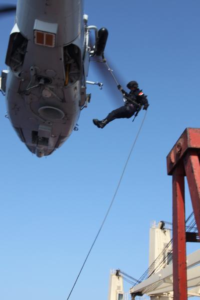 A Chinese soldier slides down from a helicopter onto a &apos;target&apos; Chinese merchant ship during an anti-piracy drill of the Chinese People&apos;s Liberation Army (PLA) Navy Eighth Escort Task Force in Gulf of Aden, on April 9, 2011. The Chinese People&apos;s Liberation Army (PLA) Navy Eighth Escort Task Force carried out the anti-piracy drill here on a Chinese merchant ship on Saturday. [Qiu Junsong/Xinhua]