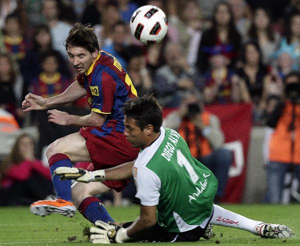 Barcelona's Lionel Messi (L) fights for the ball against Almeria's goalkeeper Diego Alves during their Spanish first division soccer match at Camp Nou stadium in Barcelona April 9, 2011. [Xinhua]