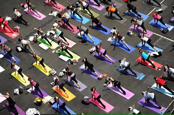 Participants take part in the Yogathon, a group yoga challenge raising fund for the Hong Kong Breast Cancer Foundation in Hong Kong, south China, April 10, 2011. Dozens of participants joined the 10 hours' yoga marathon to promote health awareness among Hong Kong citizens via yoga practice. (Xinhua/Chen Xiaowei) 