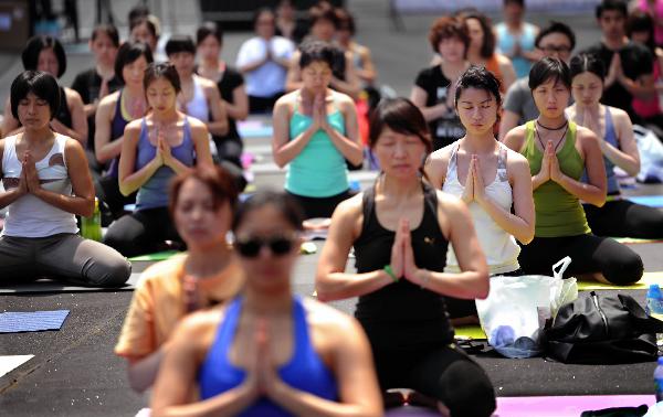 Participants take part in the Yogathon, a group yoga challenge raising fund for the Hong Kong Breast Cancer Foundation in Hong Kong, south China, April 10, 2011. (Xinhua/Chen Xiaowei) 