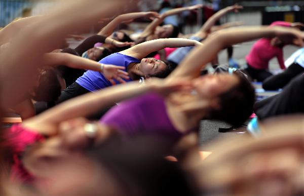 Participants take part in the Yogathon, a group yoga challenge raising fund for the Hong Kong Breast Cancer Foundation in Hong Kong, south China, April 10, 2011. (Xinhua/Chen Xiaowei)