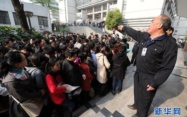 An exam supervisor maintains order at an exam site in Hefei, East China's Anhui province, April 10, 2011, before the start of the 2011 Anhui Provincial Public Servant Exam. The province kicked off a written test for the selection of civil servants Sunday, attracting more than 100,000 candidates for 5,352 vacancies. [Photo/Xinhua] 