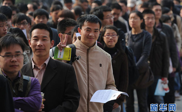 A candidate, flashing a V sign, lines up to enter an exam hall for the 2011 Anhui Provincial Public Servant Exam in Hefei, east China's Anhui Province, April 10, 2011. [Photo/Xinhua]