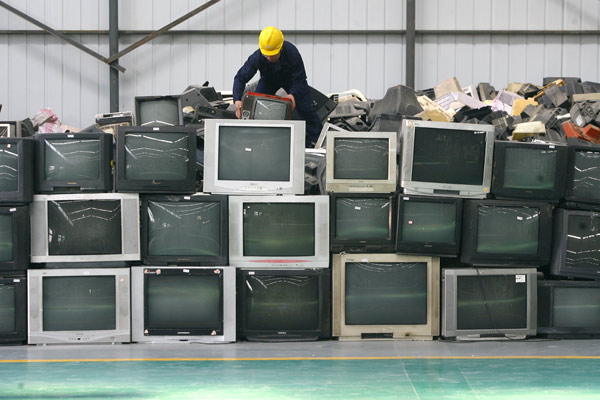 A worker processes disused TV sets at a resource recycling industrial park in Wuhan, Central China's Hubei province. The park is able to recycle 30,000 tons of discarded electronic appliances every year, including washing machines, refrigerators and air conditioners. [File photo/Xinhua] 