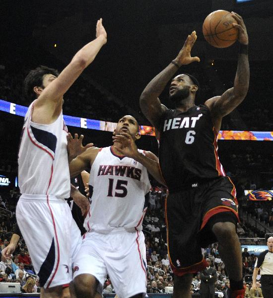 Miami Heat forward LeBron James (R) drives against Atlanta Hawks center Zaza Pachulia (L) and forward Al Horford in the first half of their NBA basketball game in Atlanta, Georgia April 11, 2011. (Xinhua/Reuters Photo)