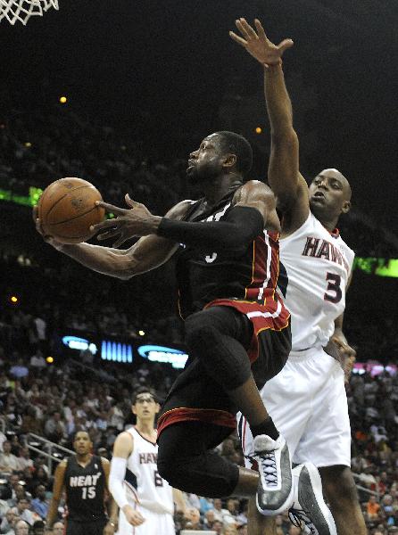 Miami Heat guard Dwayne Wade shoots under the basket past Atlanta Hawks guard Damien Wilkins in the first half of their NBA basketball game in Atlanta, Georgia April 11, 2011. (Xinhua/Reuters Photo)