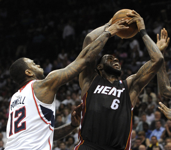 Miami Heat forward LeBron James (R) battles to get past Atlanta Hawks forward Josh Powell in the second half of their NBA basketball game in Atlanta, Georgia April 11, 2011. (Xinhua/Reuters Photo)