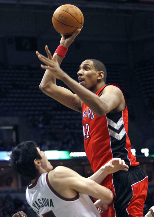 Milwaukee Bucks' Ersan Ilyasova (L) defends against Toronto Raptors' Alexis Ajinca (R) in the first halfof their NBA basketball game in Milwaukee, Wisconsin April 11, 2011. (Xinhua/Reuters Photo) 