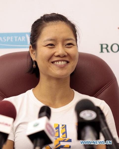 Chinese tennis player Li Na smiles during a news conference in Doha on Feb. 21, 2011. [Xinhua photo]