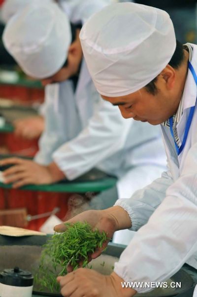 Contestants show their skills in the stir-frying of the Longjing (Dragon Well) Tea during a tea fair held in Xinchang County, east China's Zhejiang Province, April 11, 2011. 