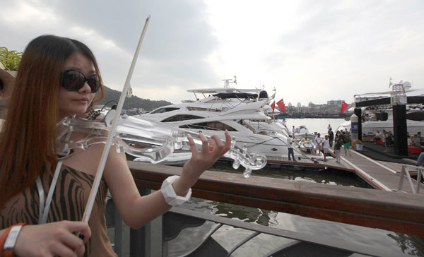 A violinist plays at the Haitian Shengyan (Sea and Sky Grand Banquet) Luxury Exhibition for yachts, private planes and other luxurious goods at Sanya, South China's Hainan province, on April 1. 