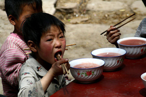 One daughter eats vegetables grown by her family at a lunch in Sunyuan village of Luoyang city, Central China's Henan province, April 10, 2011. 