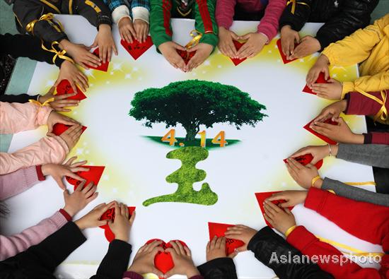 Children at a kindergarten in Zhuji, Zhejiang province, remember the victims of the earthquake in Yushu, Qinghai province, on April 13, 2011, a day before the first anniversary of the disaster that killed 2,698 people. [Photo/Asianewsphoto] 