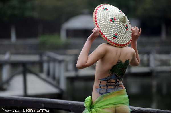 A model with paintings on her body strikes a pose at the Enlong scenic spot in Ningguo city, East China's Anhui province, April 13, 2011.
