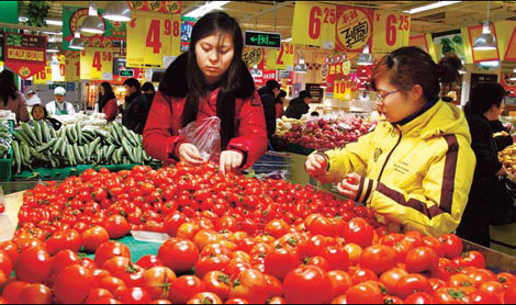 Customers choose tomatoes at a supermarket in Beijing. Analysts said that the faster-than-expected growth in money supply and lending may aggravate the country's already high inflationary pressure and prompt policymakers to adopt more monetary-tightening measures. [China Daily] 