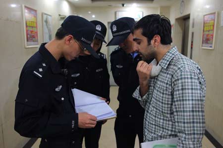 Police check a foreigner's documents in the Chenghuayuan residential community near Liudaokou, Haidian district of Beijing Thursday evening. 