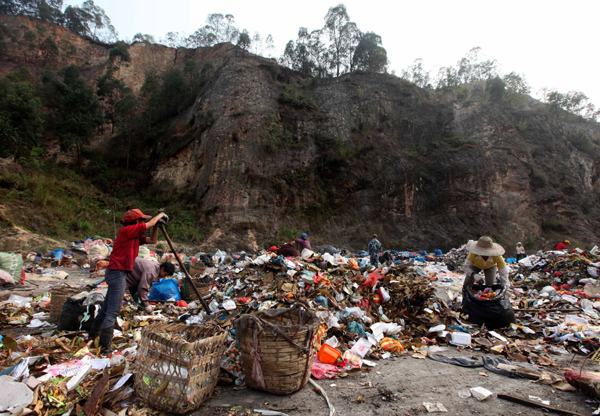 Workers pack trash at a garbage transfer station in the town of Shawan in Guangzhou's Panyu district on Tuesday. The district government listed Shawan on Tuesday as a possible location for a garbage incinerator. 