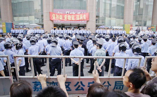 Police stand guard as two gangs start to fight in the Shisanhang Road in Guangzhou, capital of South China's Guangdong province on Friday. [Chen Wenbi/China Daily]