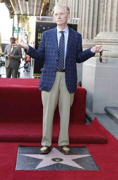 CBS news correspondent and author Bill Geist stands on his newly unveiled star on the Hollywood Walk of Fame as Lassie sits beside him in Hollywood, California April 15, 2011. [Xinhua/Reuters]