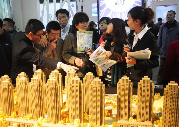 Visitors talk with property agents about a housing project during a Spring real estate fair in Dalian, northeast China's Liaoning Province, April 2011. 
