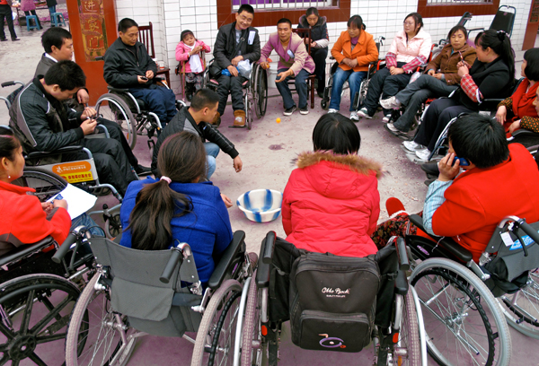 Survivors disabled by spinal cord injuries during the quake play games to overcome isolation through a 26-member peer support group in rural Mianzhu city in this 2011 photo. NGO Handicap International started the group to help members adjust to their new life in wheel chairs. [China Daily]