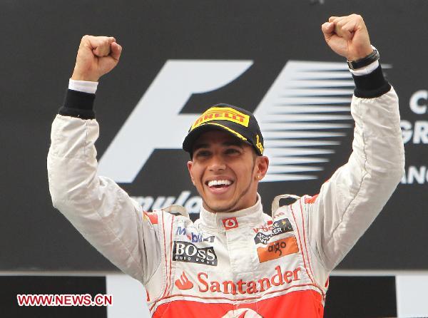 McLaren Formula One driver Lewis Hamilton of Britain celebrates on the podium after winning the Chinese F1 Grand Prix at Shanghai International circuit April 17, 2011. Hamilton claimed the title with 1:36:58.226. (Xinhua/Fan Jun)