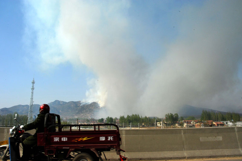 A mountain fire breaks out around the mountainous area in east China&apos;s Shandong Province around 9 a.m. on April 18, 2011 and spreads toward Mount Tai, according to a report from local authorities. [Xinhua] 