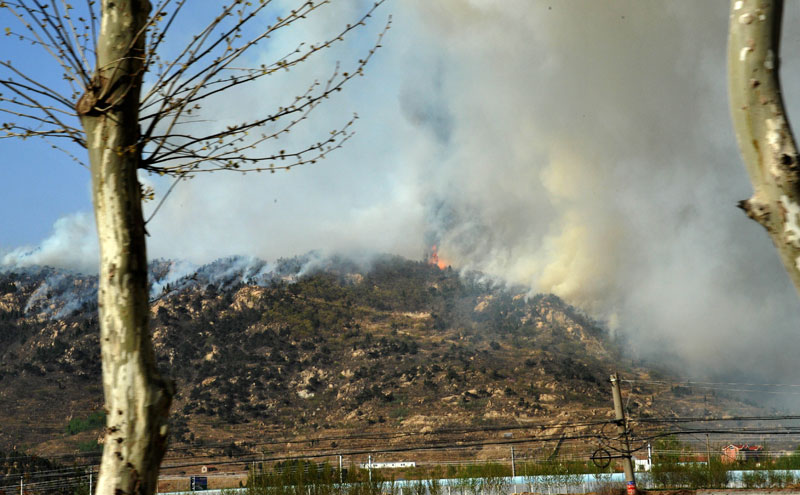 A mountain fire breaks out around the mountainous area in east China&apos;s Shandong Province around 9 a.m. on April 18, 2011 and spreads toward Mount Tai, according to a report from local authorities. [Xinhua] 