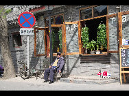 An old man bathing in the sun in Nanluoguxiang. [China.org.cn by Li Xiaohua]