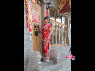 A woman wearing traditional Chinese qipao in Nanluoguxiang. [China.org.cn by Li Xiaohua]