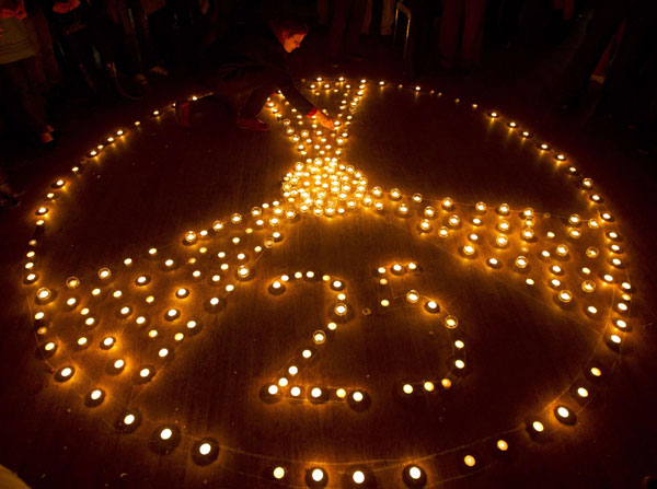 A participant of the International partner conference '25 years after Chernobyl' lights a candle in Minsk April 18, 2011. Belarus, Ukraine and Russia will mark the 25th anniversary of the nuclear reactor explosion in Chernobyl, the place where the world's worst civil nuclear accident took place, on April 26. [Agencies via China Daily]