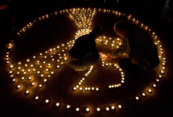 Participants of the International partner conference '25 years after Chernobyl' light candles in Minsk April 18, 2011. [Agencies via China Daily]