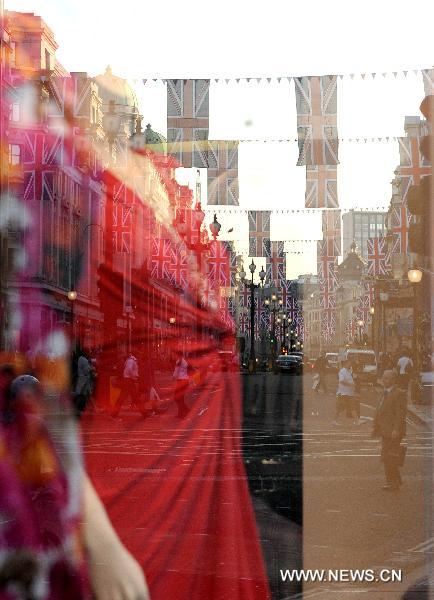 British flags are reflected on a window of a store on Regent Street in central London, April 19, 2011. A bunting of British flags goes up on Regent Street to celebrate the upcoming wedding of Prince William and his fiancée Kate Middleton, which will be held at Westminster Abbey in London on April 29. [Xinhua]