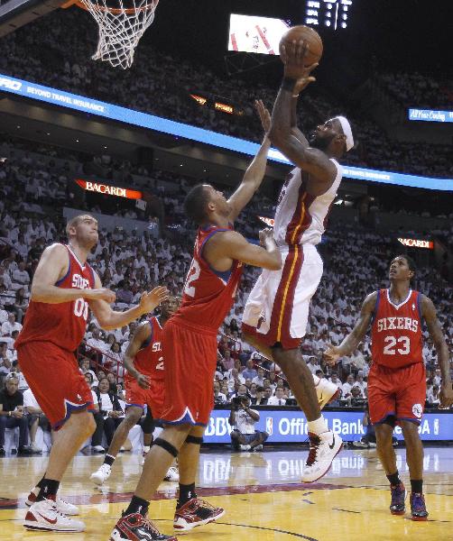 Miami Heat small forward LeBron James (2nd R) shoots as Philadelphia 76ers power forward Elton Brand (2nd L), Spencer Hawes (L) and Lou Williams (R) defend in the first half during Game 2 of their NBA Eastern Conference playoff series in Miami April 18, 2011. (Xinhua/Reuters Photo)