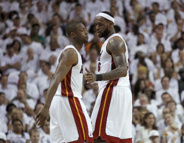 Miami Heat shooting guard Dwyane Wade (L) and LeBron James speak during the second half of Game 2 of their NBA Eastern Conference playoff series in Miami April 18, 2011. (Xinhua/Reuters Photo)