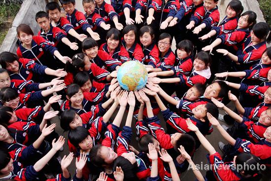 Students prop up a globe in a circle for the upcoming Earth Day, April 22, at a middle school in Dexing, East China&apos;s Jiangxi province, April 19, 2011. [Asianewsphoto] 