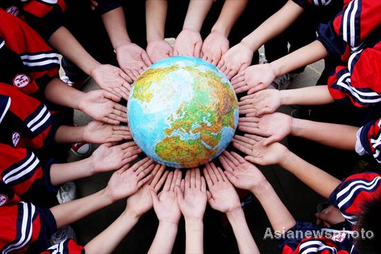 Students prop up a globe for the upcoming Earth Day, April 22, at a middle school in Dexing, East China&apos;s Jiangxi province, April 19, 2011. 