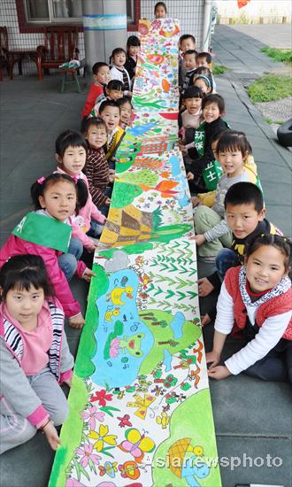 Children show a scroll they painted for the upcoming Earth Day, April 22, at a kindergarten in Suzhou, East China&apos;s Jiangsu province, April 19, 2011. 