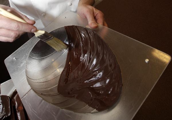 La Maison du Chocolat's creative director Gilles Marchal uses a brush to coat the inside of an egg-shaped mould with chocolate in preparations for Easter at their workshop in Nanterre, near Paris April 20, 2011. Some 13,000 tonnes of chocolate are sold in France during the Easter holiday period, which counts for 3.5 percent of total yearly sales or even more for luxury chocolate stores. [Xinhua/Reuters]