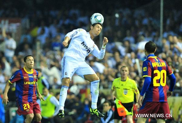 Real Madrid's Cristiano Ronaldo (C) heads the ball during the King's Cup final soccer match against Barcelona at Mestalla stadium in Valencia, Spain, April 20, 2011. Real Madrid claimed the champion by defeating Barcelona 1-0. [Chen Haitong/Xinhua]