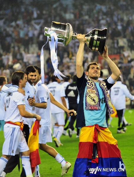 Real Madrid's captain Iker Casillas (R) celebrates with the trophy after winning the King's Cup final soccer match against Barcelona at Mestalla stadium in Valencia, Spain, April 20, 2011. Real Madrid claimed the champion by defeating Barcelona 1-0. [Chen Haitong/Xinhua]