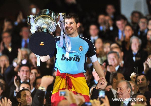 Real Madrid's captain Iker Casillas celebrates with the trophy after winning the King's Cup final soccer match against Barcelona at Mestalla stadium in Valencia, Spain, April 20, 2011. Real Madrid claimed the champion by defeating Barcelona 1-0. [Chen Haitong/Xinhua]