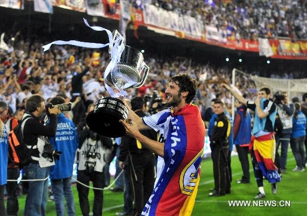 Real Madrid's Esteban Granero celebrates with the trophy after winning the King's Cup final soccer match against Barcelona at Mestalla stadium in Valencia, Spain, April 20, 2011. Real Madrid claimed the champion by defeating Barcelona 1-0. [Chen Haitong/Xinhua]