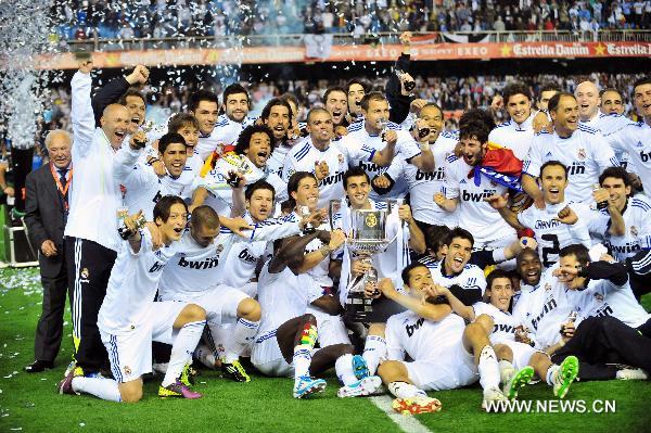 Real Madrid's members pose together with the trophy after winning the King's Cup final soccer match against Barcelona at Mestalla stadium in Valencia, Spain, April 20, 2011. Real Madrid claimed the champion by defeating Barcelona 1-0. [Chen Haitong/Xinhua]