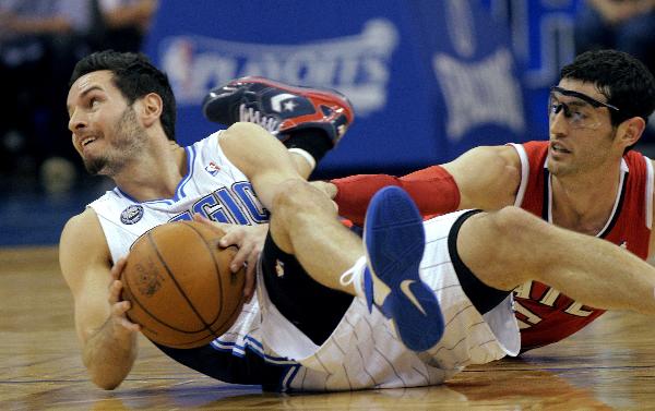 Orlando Magic guard J.J. Redick (L) gets a loose ball beside Atlanta Hawks guard Kirk Hinrich (R) during the first half of Game 2 of their NBA Eastern Conference first round playoff basket ball game in Orlando, Florida April 19, 2011. (Xinhua/Reuters Photo) 