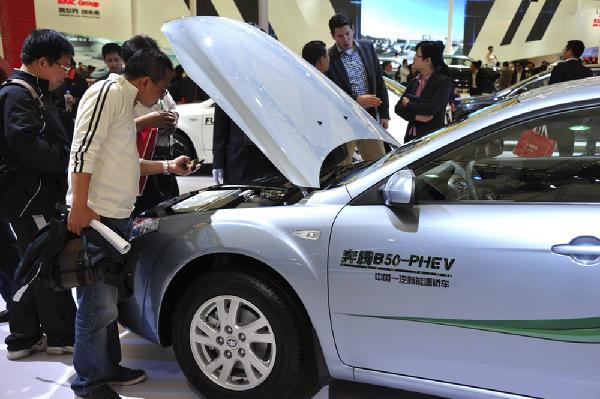 Visitors take a look at the engine of a Besturn B50 plug-in hybrid car during the preview of the 14th Shanghai International Automobile Industry Exhibition in east China&apos;s Shanghai, April 20, 2011. The 14th Shanghai International Automobile Industry Exhibition will be open to the public from April 21 to 28. About 2,000 carmakers and parts providers from 20 countries are due to showcase 1,100 car models, 75 of which makes their world premieres in the auto show. 